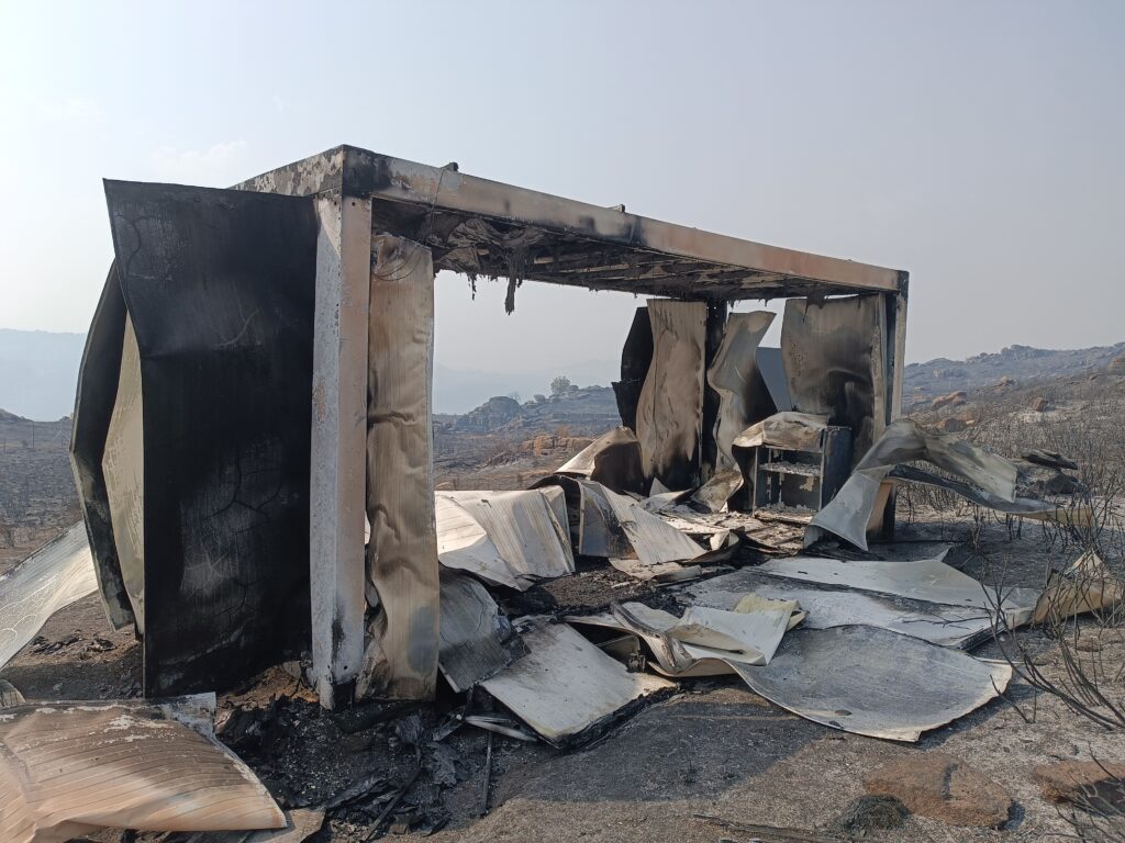 Destruction of the support container for the Cinereous Vulture acclimatisation programme. The vast extent of burnt area in the surroundings is visible. ©Palombar 
