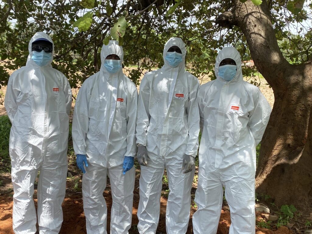 four people dressed in contamination suits and masks